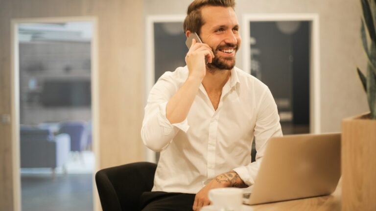 Business owner answering a customer call at his laptop